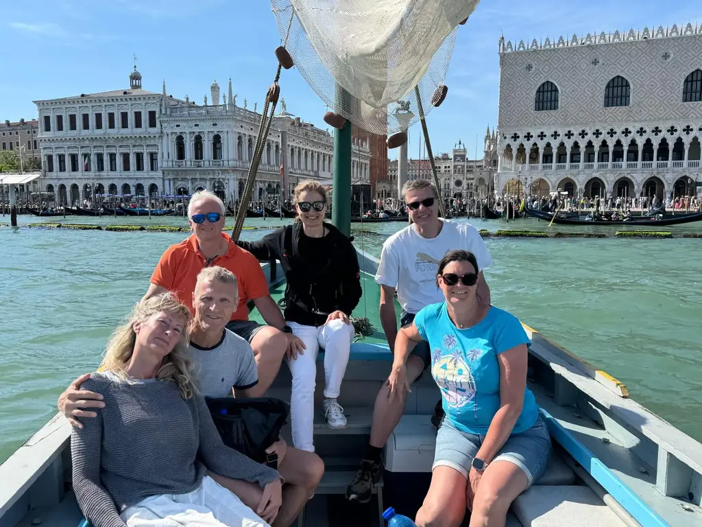 Group picture of guests on Stella, a classic 1965 Bragozzo, in front of Piazza San Marco
